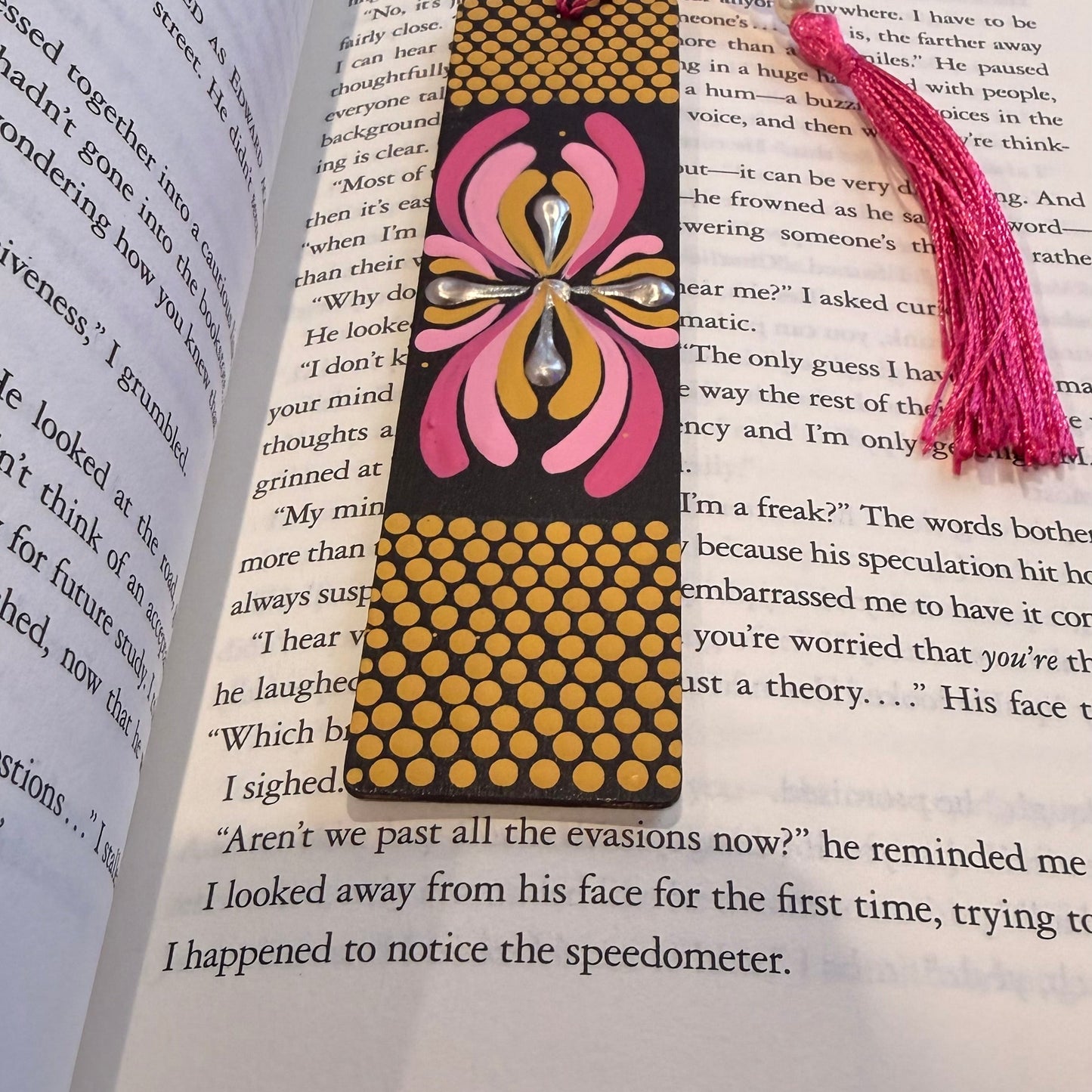 Decorative bookmark with pink and yellow design on an open book