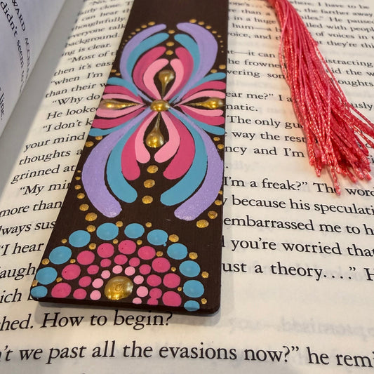 Colorful butterfly-shaped bookmark with tassel on an open book