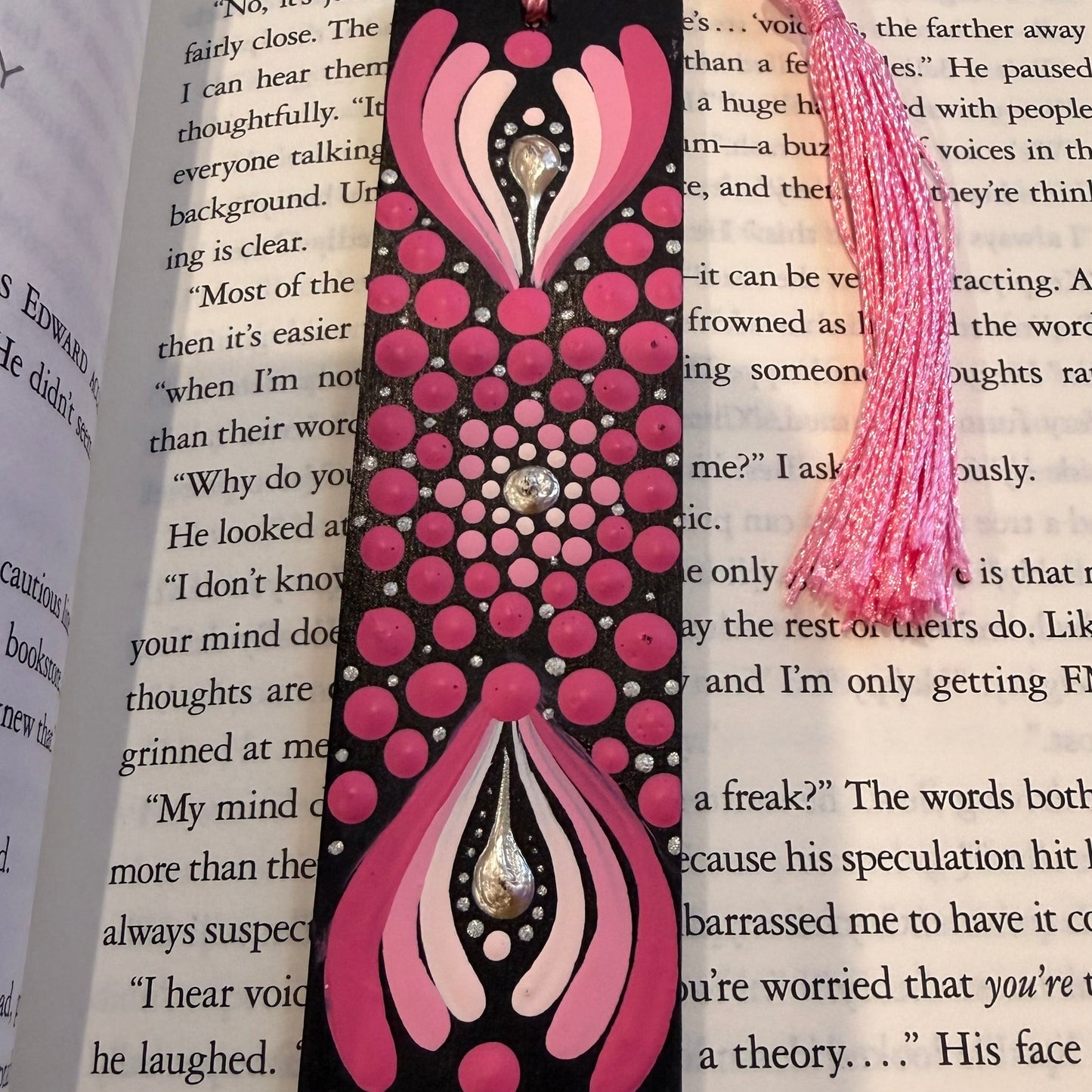 Pink and black decorative bookmark on an open book
