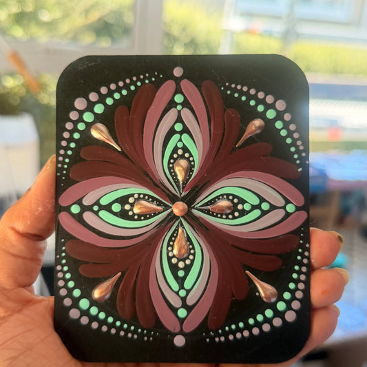 Hand holding a phone case with a decorative floral design.