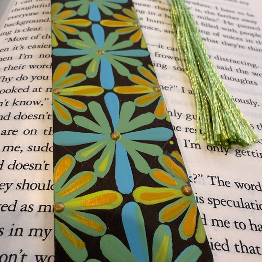 Decorative bookmark with floral pattern and tassel on an open book