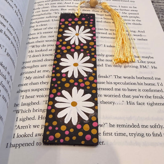 Decorative bookmark with daisy design on an open book