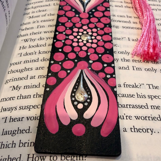 Decorative pink and black bookmark with a heart design on an open book.